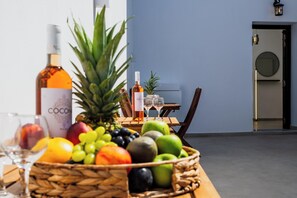 Ein Tisch mit Obstkorb, einer COCONUT-Flasche und zwei Weingläsern.
