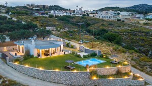 A modern house with a swimming pool, stone walls, and a well-maintained lawn. - High View Villa in Afantou (Rhodes)