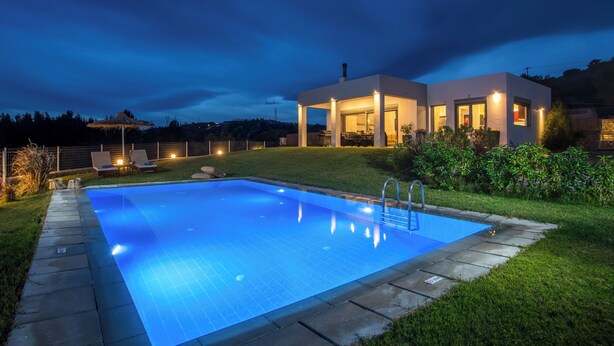 A modern house with a swimming pool, surrounded by a well-maintained lawn and a clear night sky. - High View Villa in Afantou (Rhodes)