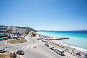 A coastal road with a beach, vehicles, and buildings. - Molos Seaside Apartment in Rhodes Town (Rhodes)