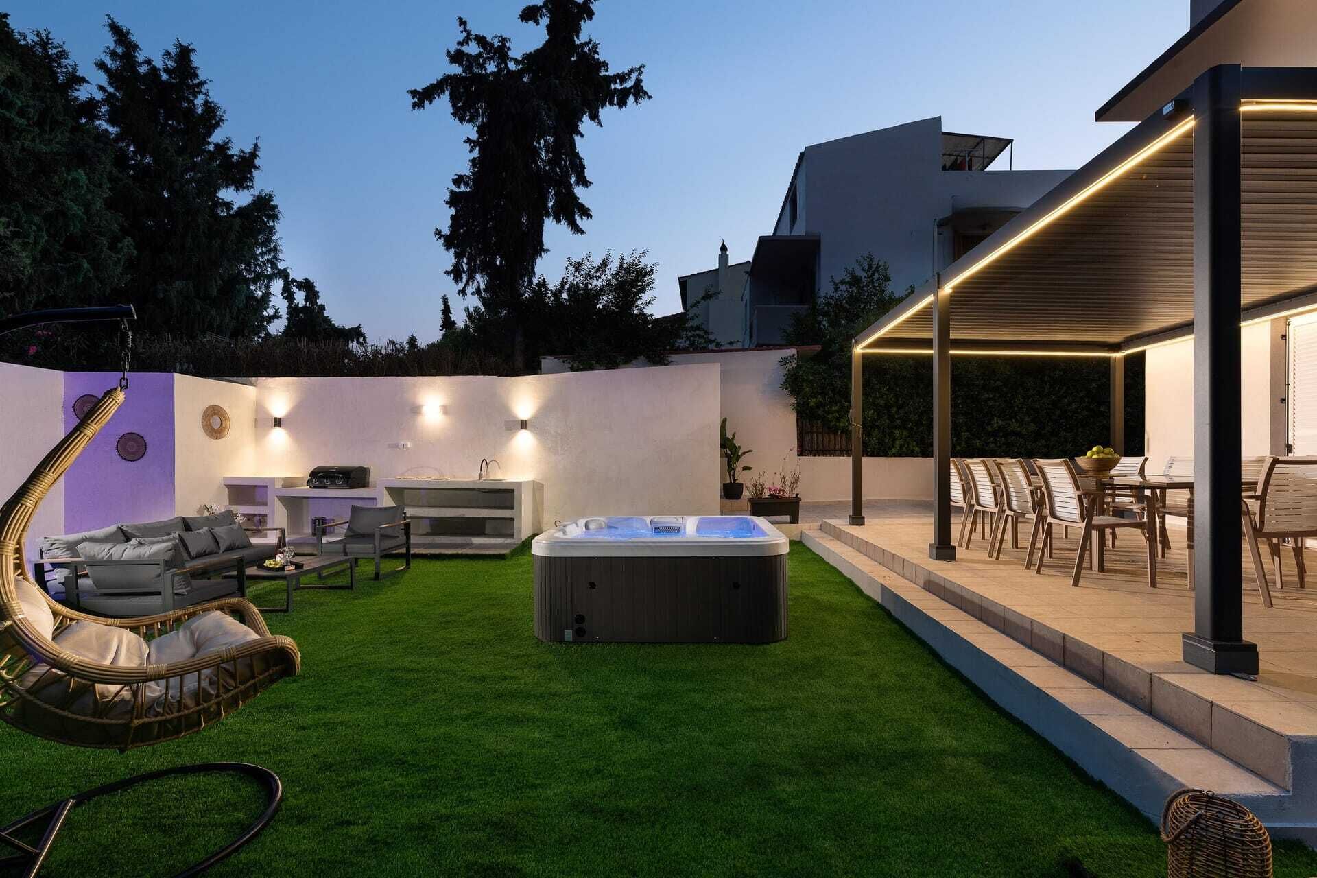A backyard with a hot tub, outdoor seating, and a barbecue area.
