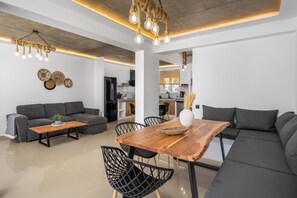 Ein modernes Wohnzimmer mit einer Couch, einem Holztisch und einem Esstisch mit Stühlen.