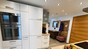 Eine moderne Küche mit eingebauten Geräten, einer Holz Arbeitsplatte und einer Obstschale.