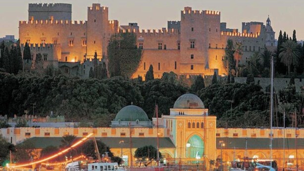 A waterfront marina with several boats docked, a castle-like building in the background, and a prominent dome structure in the foreground. - Retreat Apartment in Rhodes Town (Rhodes)