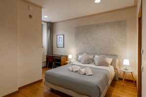 A hotel room with a bed, bedside tables, a desk, and a chair. - Rivoli Gallery Residence (Verona)