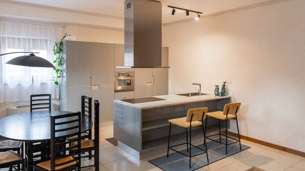 A modern kitchen with a central island, a dining area with chairs, and a pendant light. - Rivoli Gallery Residence (Verona)