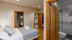 A bedroom with a bed, a wooden door, a bathroom with a toilet, and a shower. - Rivoli Gallery Residence (Verona)
