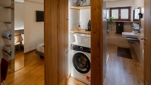 A compact room with a washing machine, a small sink, and a mirror. - Rivoli Gallery Residence (Verona)