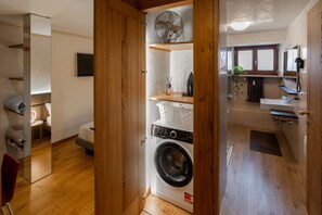 A compact room with a washing machine, a small sink, and a mirror. - Rivoli Gallery Residence (Verona)