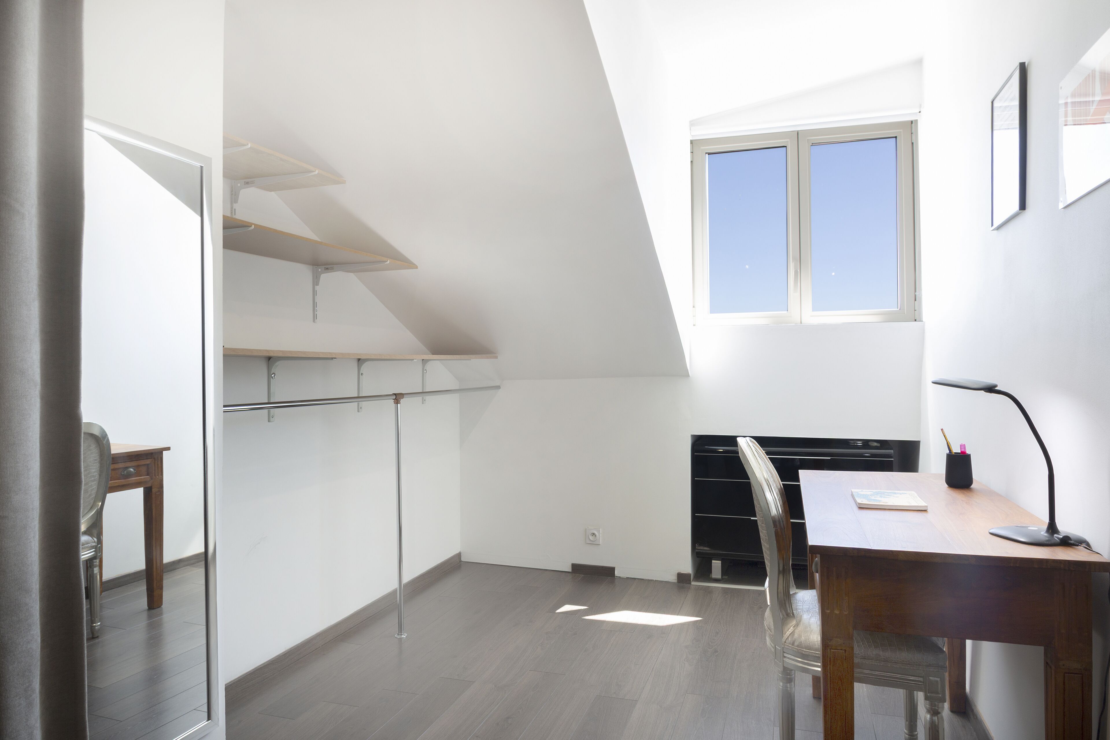 A room with a desk, chair, and a window.