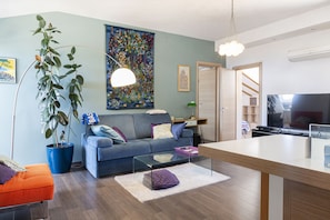A living room with a sofa, coffee table, and a TV. - Superb apartment in the center of town (Bastia)