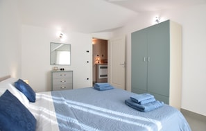 Un dormitorio con cama, cómoda, armario y espejo.