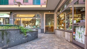A stone-paved walkway leading to a building with large glass windows displaying various items. - 1 bedroom awesome apartment in Recco (Recco)