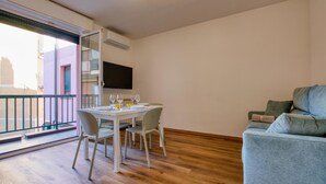 A dining area with a table set for four, a sofa, and a TV mounted on the wall. - 1 bedroom awesome apartment in Recco (Recco)