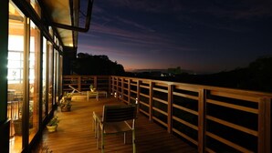 A wooden deck with a railing, potted plants, and a bench. - Kaiko Roman NO Yado Kisara (TOBA SHI)