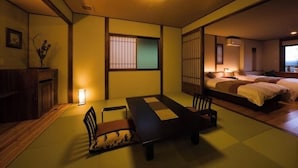 A traditional Japanese room with tatami flooring, a low table with cushions, a bed with futon beds, and a sliding door. - Kaiko Roman NO Yado Kisara (TOBA SHI)