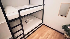 A bunk bed with a ladder, a small trash bin, and a potted plant. - Family-Friendly Room in Siargao Air-Conditioned (General Luna)