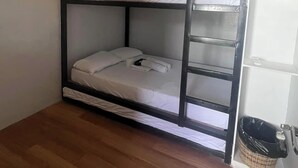 A bunk bed with a wooden frame, white bedding, and a small basket on the floor. - Family-Friendly Room in Siargao Air-Conditioned (General Luna)