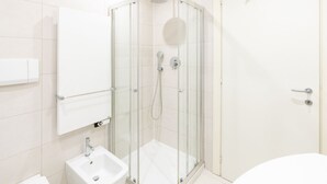 Une salle de bain moderne avec une douche à parois de verre, un lavabo et des toilettes.