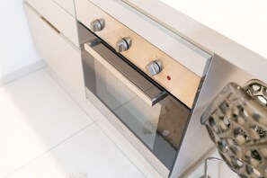 A modern kitchen with a built-in oven, stainless steel handles, and a glass door. - New Bridge House - Domus Verona (Verona)