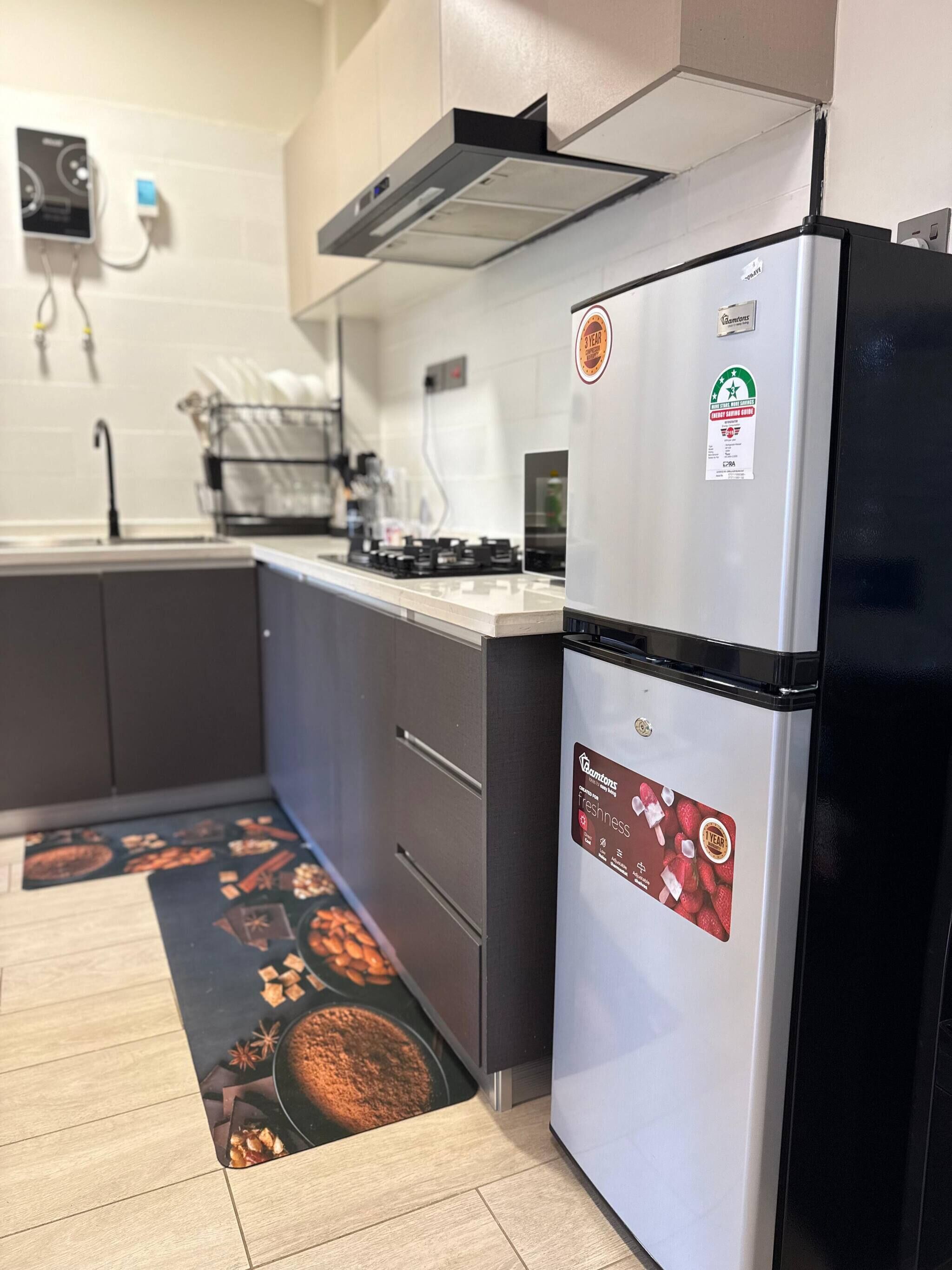 Een keuken met een roestvrijstalen koelkast, een vaatwasser en een fornuis.
