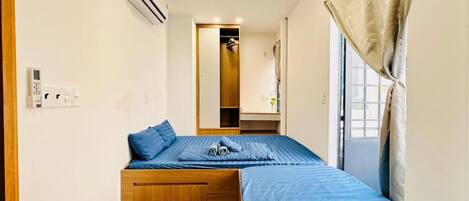A compact bedroom with a bed, bedside table, and a wardrobe.