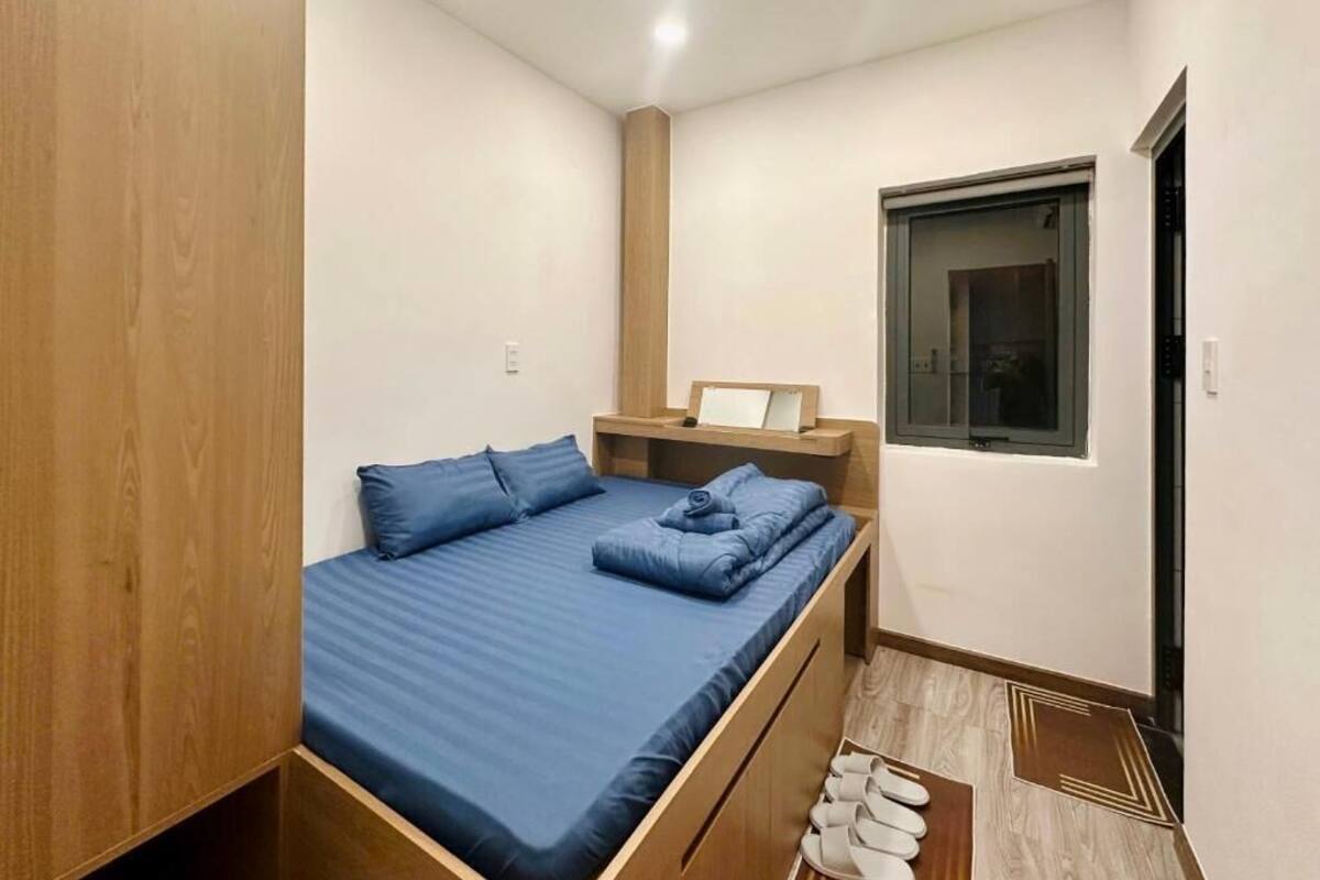 Un dormitorio pequeño y moderno con cama, armario de madera y ventana.