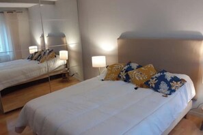 Ein Hotelzimmer mit einem großen Bett, Nachttischlampen und einem Spiegel.