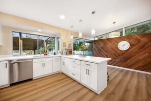 The rich herringbone wood accent wall adds warmth to this bright kitchen—natural light and modern fixtures create a cozy vibe. - Bellevue Family-Friendly 4BR Home, Near Issaquah (Bellevue)
