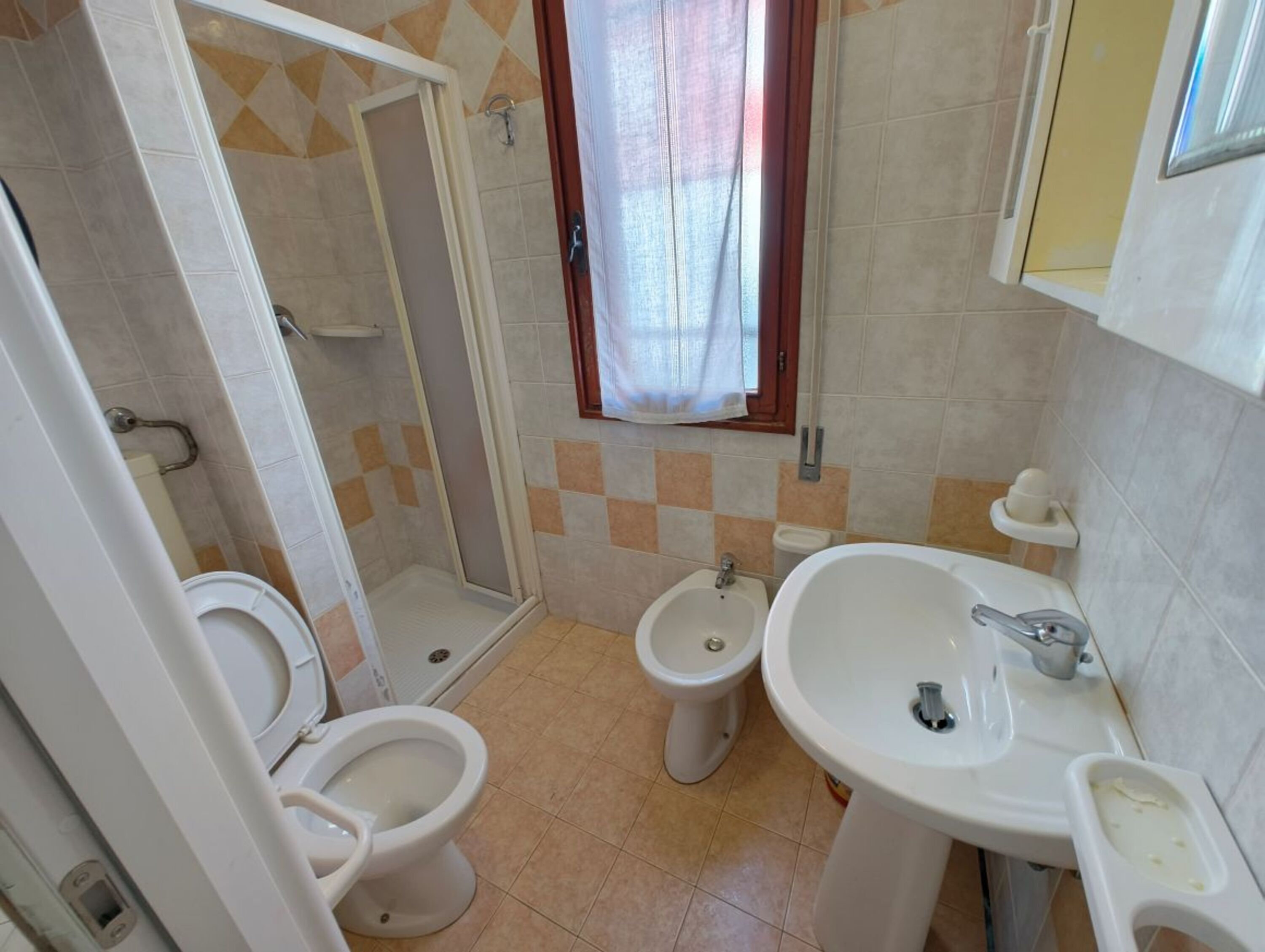 Ein Badezimmer mit Dusche, Toilette, Bidet und Waschbecken.