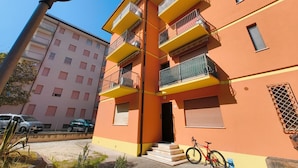 A multi-story residential building with balconies, a bicycle, and a street lamp. - Familiar Base for a Comfortable Stay in Rosolina (Rosolina)