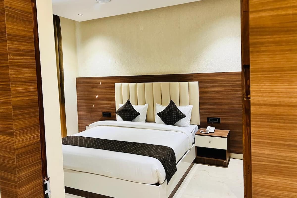A bedroom with a bed, bedside tables, a nightstand, and a ceiling fan.