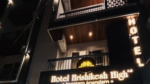 La entrada de un hotel con un cartel que dice 'Hotel Irshikesh High' y una escalera que conduce a la entrada.