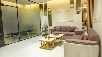 A modern living room with a sectional sofa, a coffee table, and a glass partition.