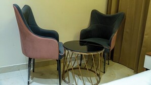 A small room with two chairs and a round table. - Hotel Hrishikesh High Tapovan 2.0 (Rishikesh)