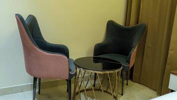 Una habitación pequeña con dos sillas y una mesa redonda.