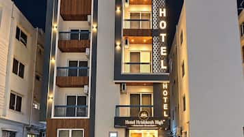 A multi-story hotel with a prominent 'HOTEL' sign, balconies, and a modern facade.