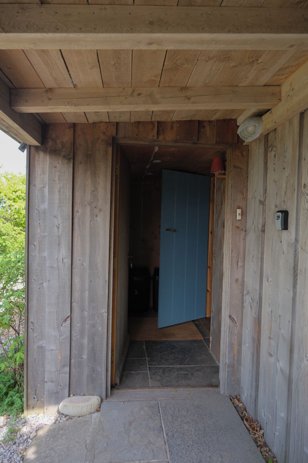 Uma estrutura de madeira com uma porta que dá para o interior.
