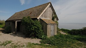Een houten gebouw in rustieke stijl met een schuin dak, een klein terras en een schotelantenne.