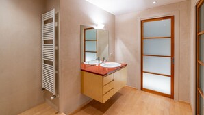 A modern bathroom with a wooden floor, a white radiator, a double sink vanity, and a frosted glass door. - Stunning residence with unique view of the Arena (Verona)