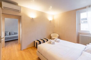 A bedroom with a bed, a chair, a radiator, and a window. - Breathtaking residence with a unique view of the arena (Verona)