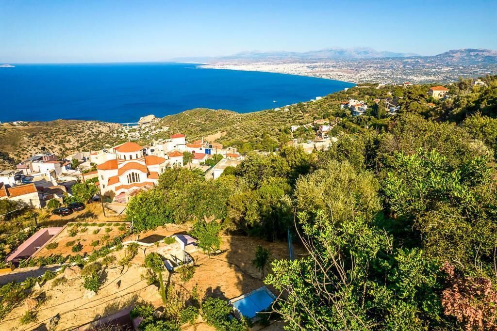 Un borgo costiero con edifici, una piscina e vista sul mare.