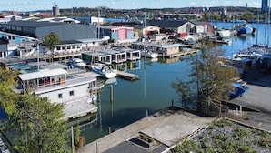 A marina with docked boats, a building with a sloped roof, and a clear sky.