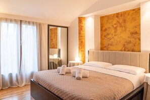A hotel room with a large bed, bedside tables, a mirror, and a view of the outdoors. - Luxurious residence with large terrace overlooking Arena (Verona)