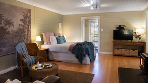 Ein gemütliches Schlafzimmer mit Bett, Fernseher und Kamin.