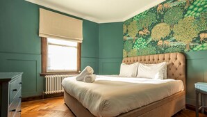 A bedroom with a large bed, a radiator, a window with a blind, and a wall mural. - South Castle Street | St Andrews (St Andrews)