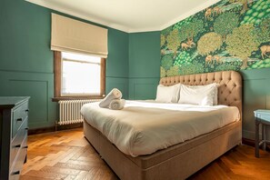 A bedroom with a large bed, a radiator, a window with a blind, and a wall mural. - South Castle Street | St Andrews (St Andrews)