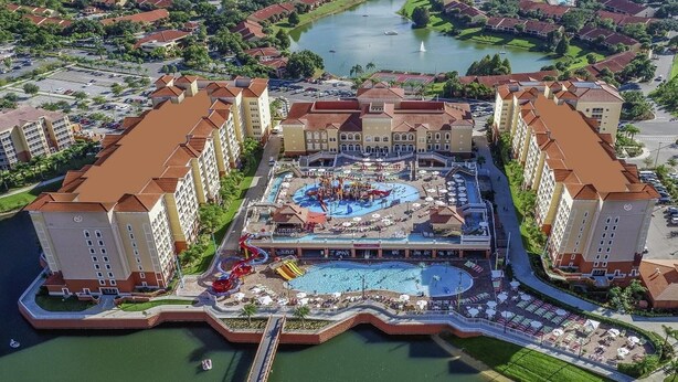 Un complejo turístico con varias edificaciones, un área de piscina central con toboganes y acceso al frente de mar.