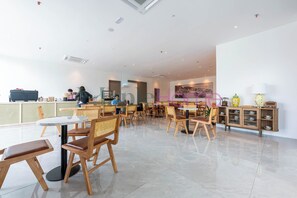 Un restaurante moderno con mobiliario de madera, una barra y un cuadro grande en la pared.