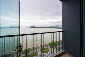 A balcony with a view of a body of water, a road, and distant mountains. - Bay Suites Premier Suites Kota Kinabalu (Kota Kinabalu)